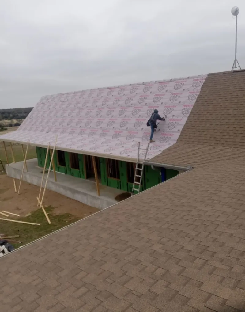 Worker preparing underlayment for a metal roof installation in Pocatello